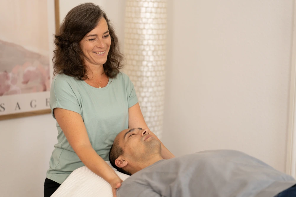 Die Klientin liegt entspannt und ihre Füße werden gehalten. Entspannung und Achtsamkeit sind Bestandteile der Fortbildung zur Körperpsychotherapie.